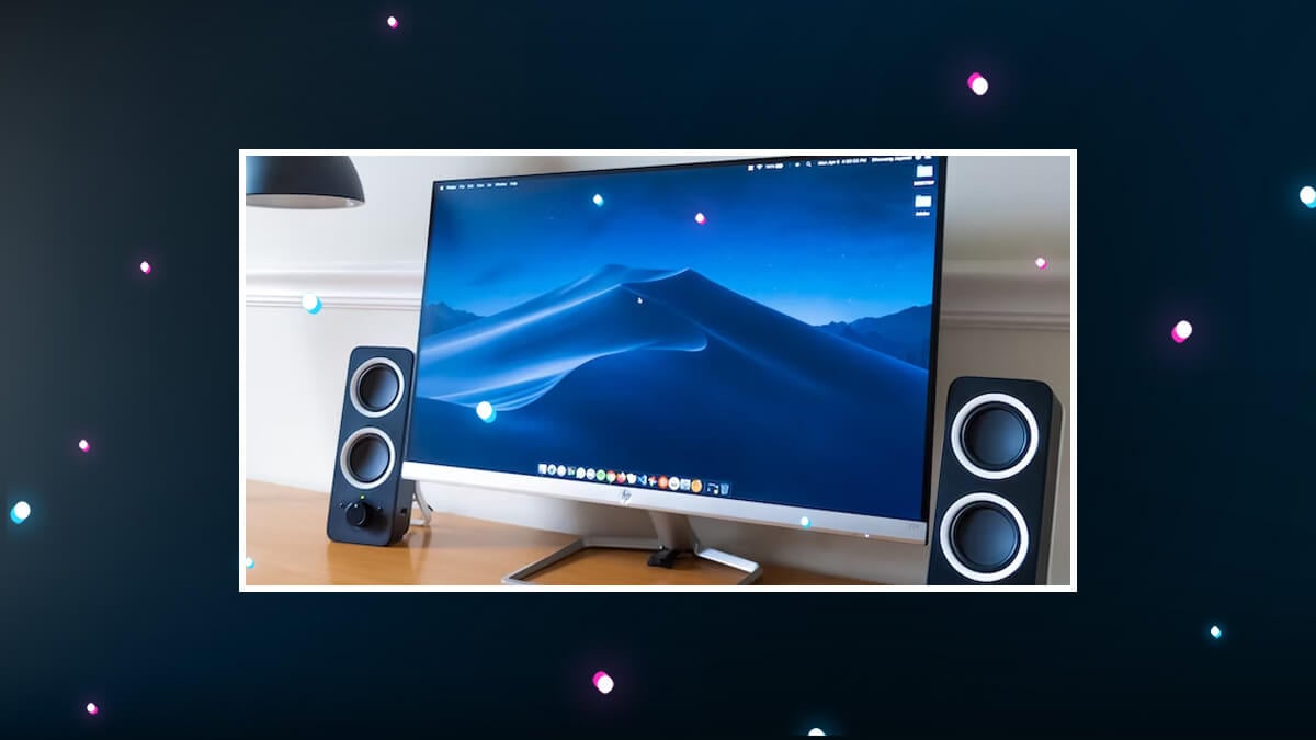 Computer monitor with desktop wallpaper, flanked by two speakers, shown on a dark graphic background.