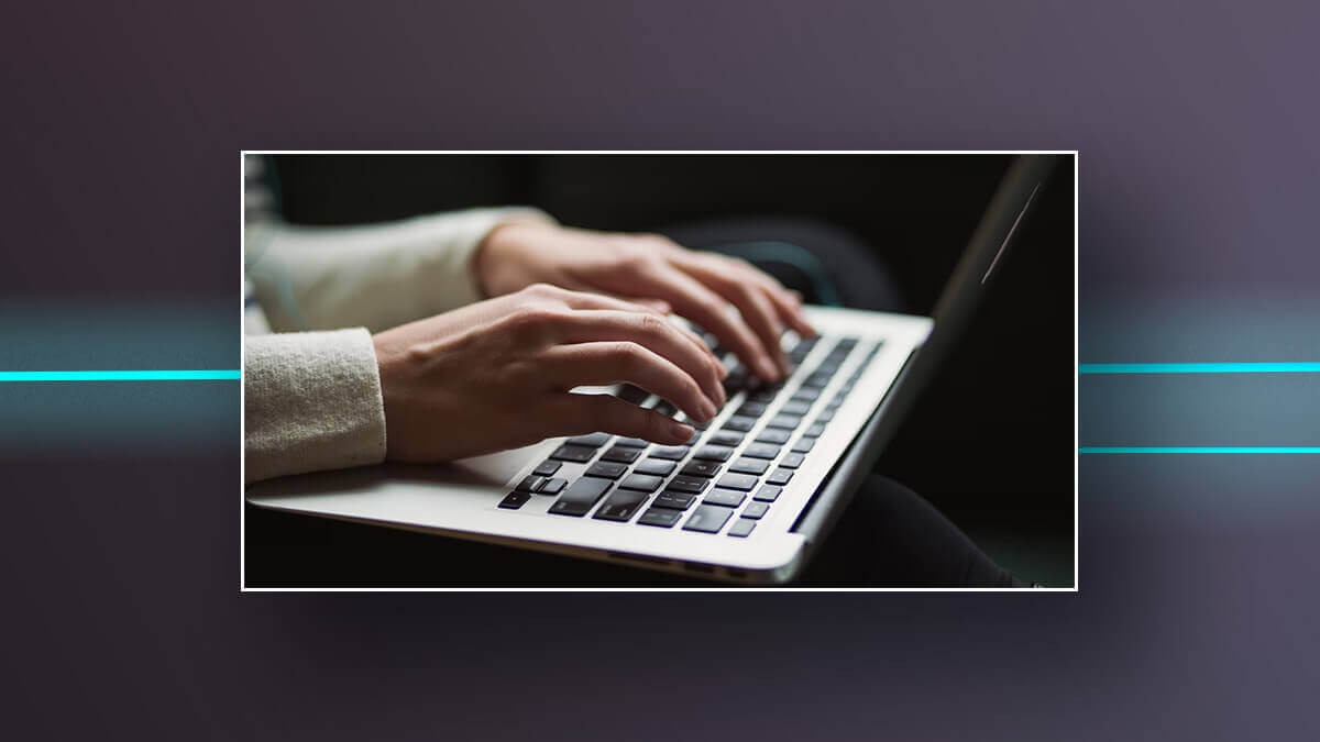 Hands typing on a laptop keyboard.