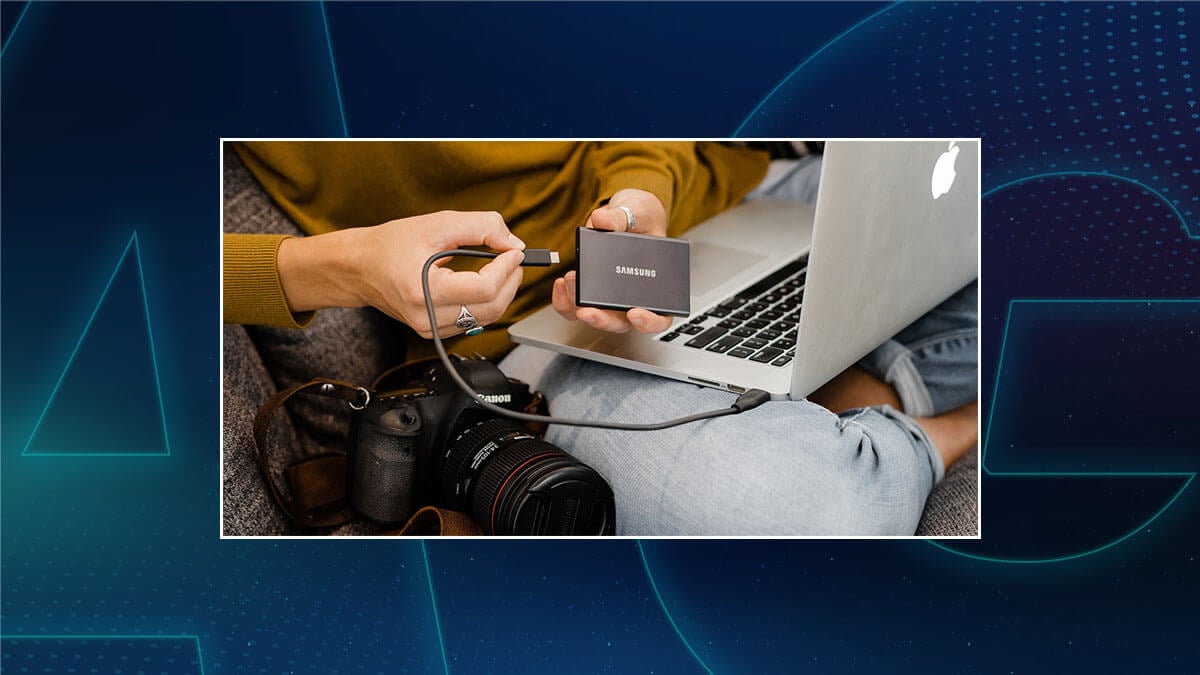 Person connecting a Samsung external SSD to a laptop, with a Canon camera nearby.