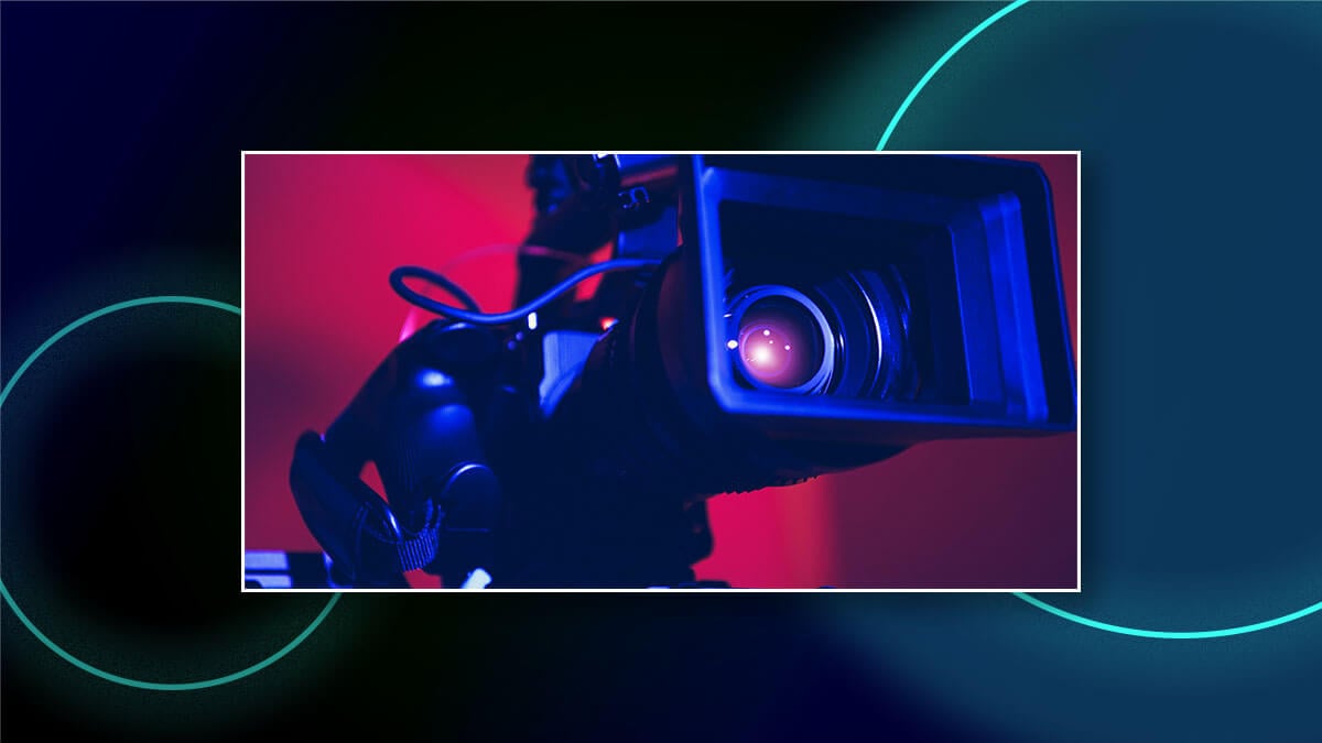 Close-up of a video camera lens lit in blue and pink, framed over a dark graphic background.