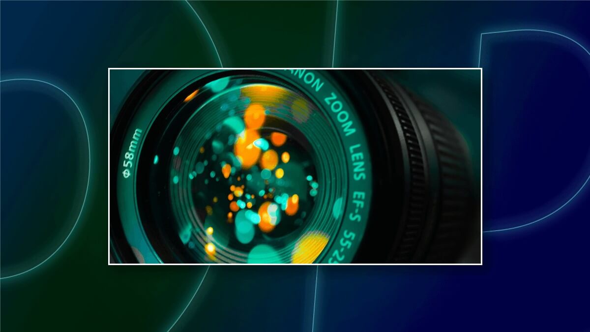 Close-up of a camera lens with colorful light reflections.