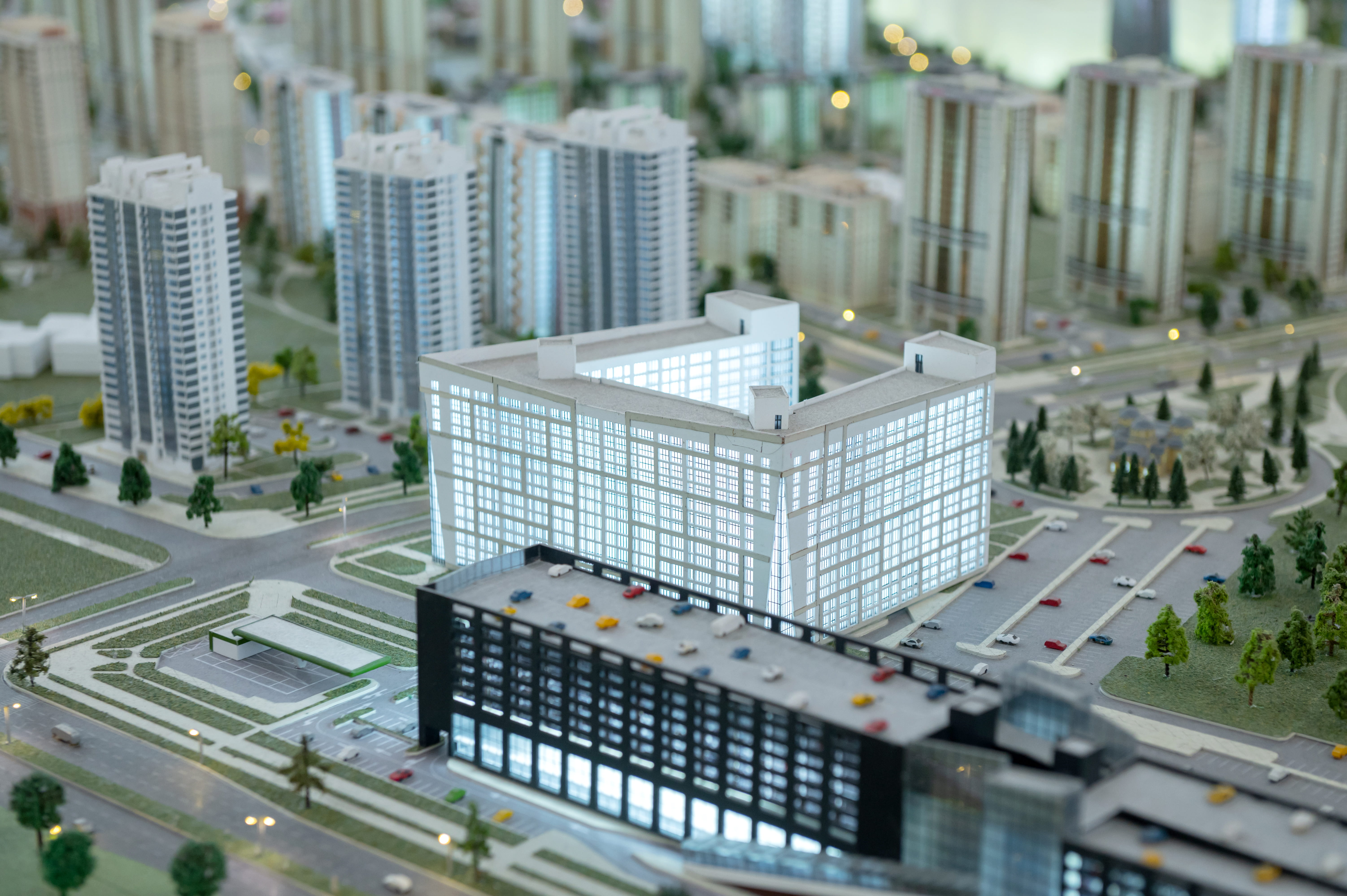 Scale model of a modern urban development with high-rise buildings, streets, parking lots, and landscaped areas.