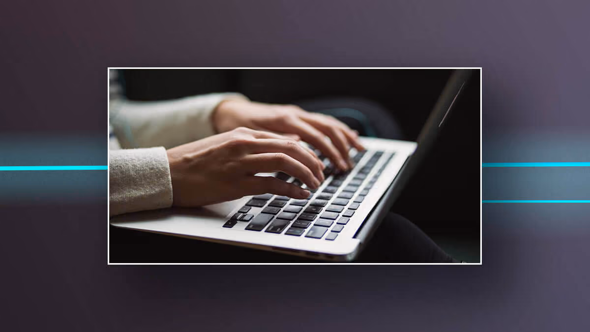 Hands typing on a laptop keyboard.
