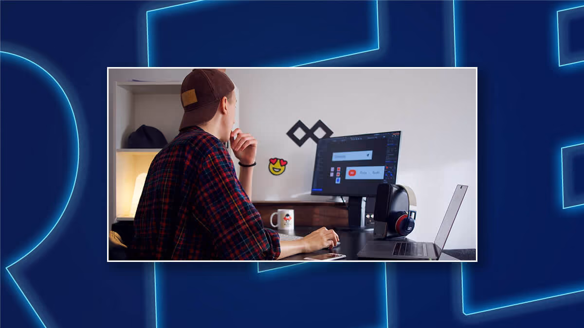 Person working at a desk with a monitor and laptop in a home office.