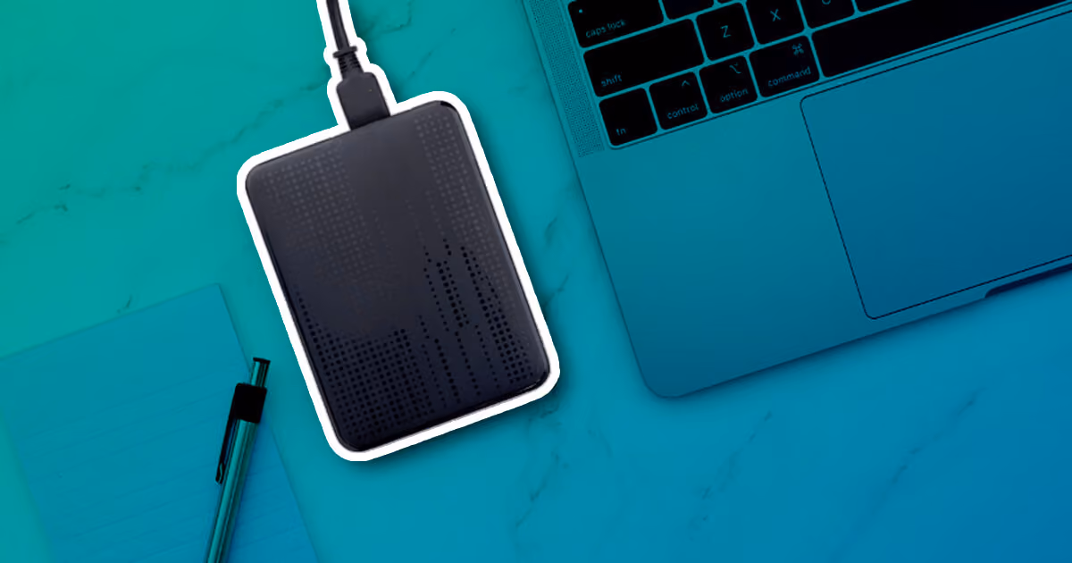 External hard drive connected beside a laptop on a desk.
