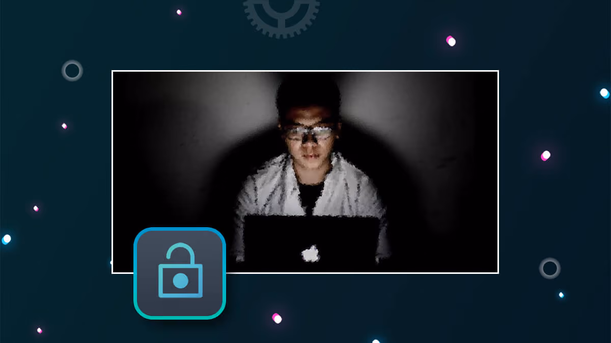 Person using a laptop in the dark with an unlocked padlock icon overlay.