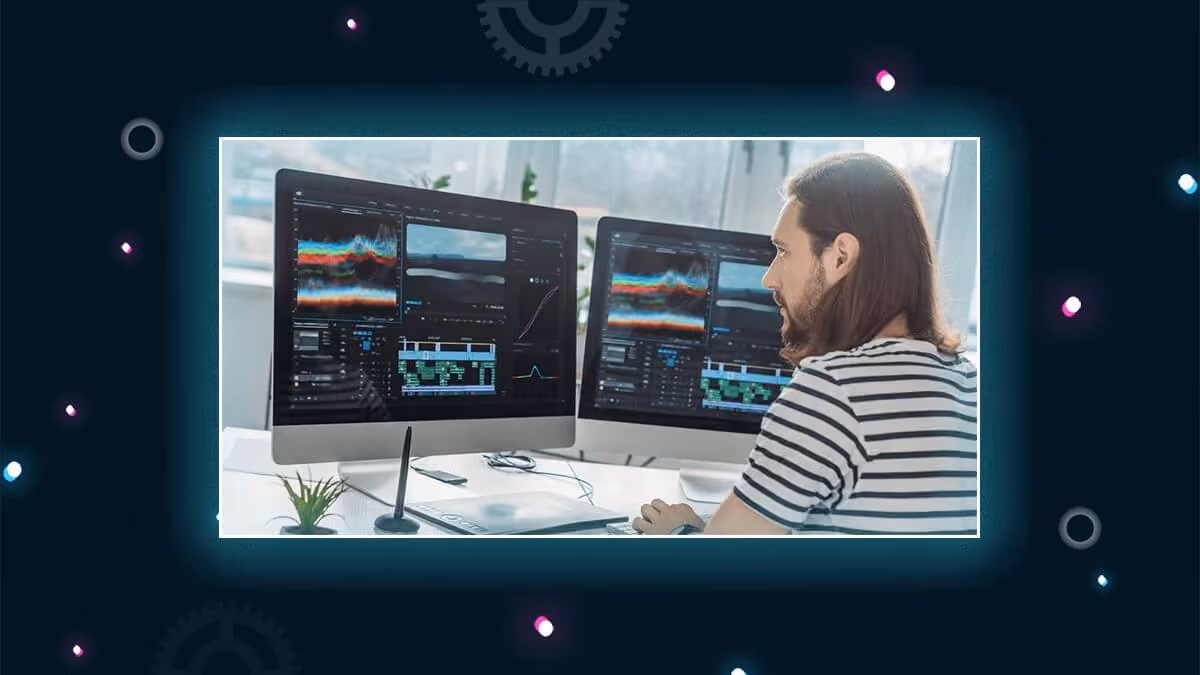 Person working at a desk with two monitors showing video editing and color scopes.
